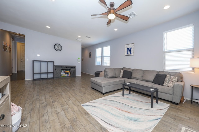 living room with light hardwood / wood-style floors and ceiling fan