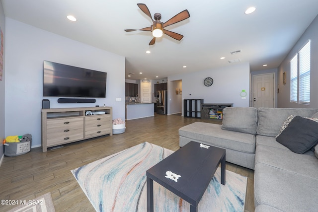 living room with hardwood / wood-style flooring and ceiling fan