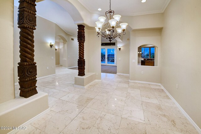 spare room with ornamental molding and a chandelier