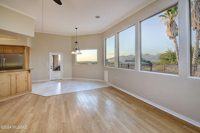 interior space featuring a mountain view, light wood-type flooring, crown molding, and an inviting chandelier