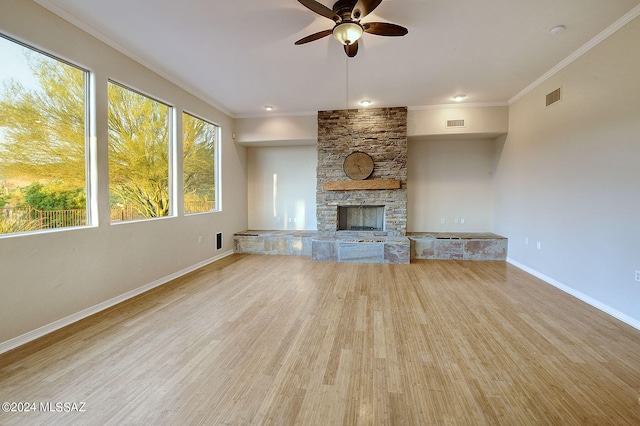 unfurnished living room with a fireplace, light wood-type flooring, ceiling fan, and ornamental molding