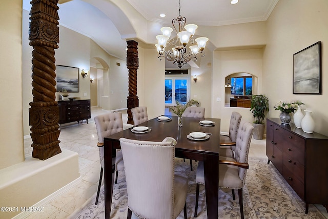 dining space with a notable chandelier, ornate columns, and crown molding