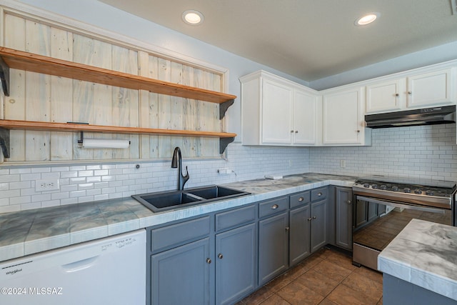 kitchen with dishwasher, sink, white cabinetry, stainless steel range oven, and tasteful backsplash