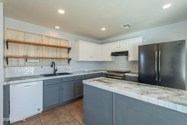 kitchen with white cabinets, tasteful backsplash, sink, gray cabinetry, and stainless steel appliances