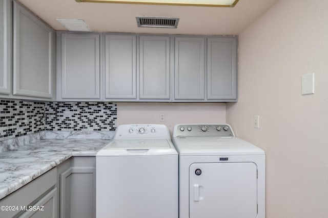 laundry room featuring cabinets and washing machine and clothes dryer