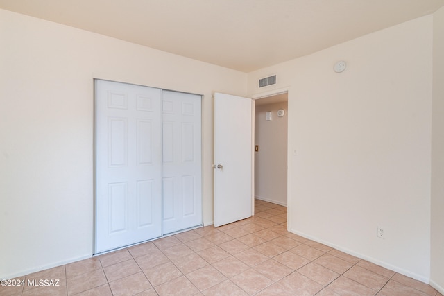 unfurnished bedroom with a closet and light tile patterned floors