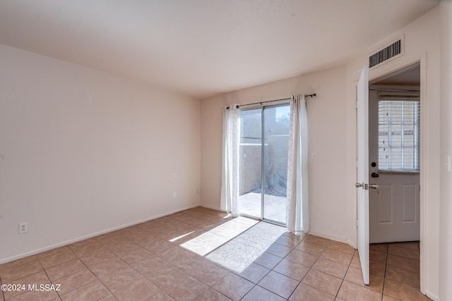 tiled spare room with a healthy amount of sunlight