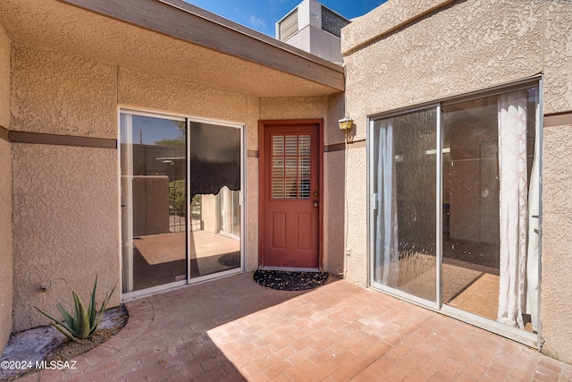 view of exterior entry featuring a patio