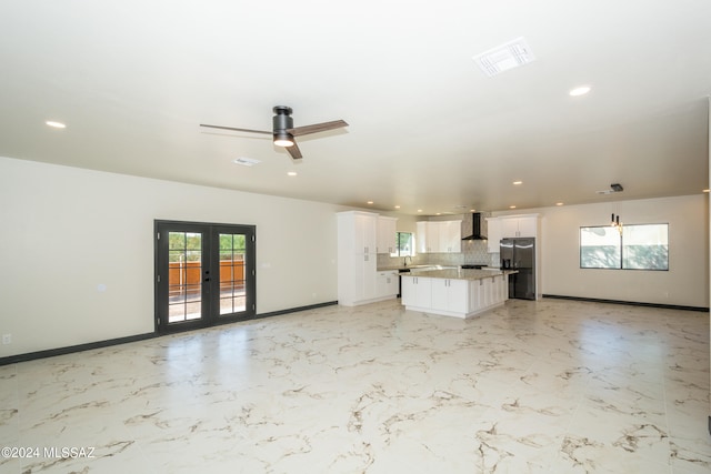 unfurnished living room featuring french doors and ceiling fan