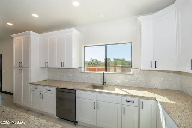 kitchen with light stone countertops, sink, black dishwasher, white cabinetry, and backsplash