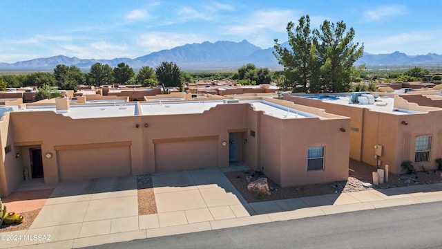 southwest-style home featuring driveway, stucco siding, and a mountain view