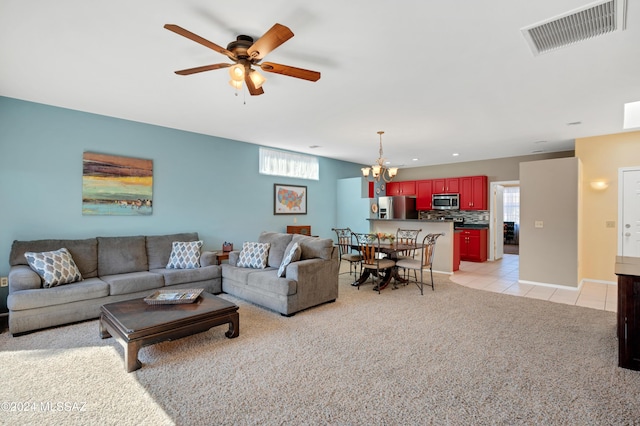 living area featuring visible vents, light tile patterned floors, baseboards, light colored carpet, and ceiling fan with notable chandelier