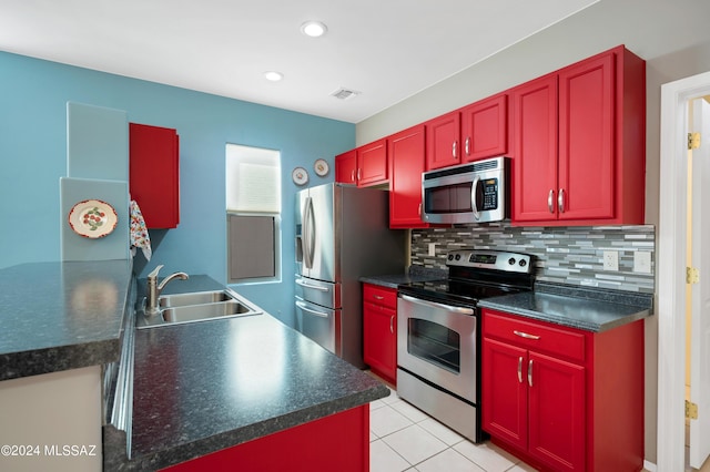 kitchen featuring dark countertops, visible vents, reddish brown cabinets, a sink, and appliances with stainless steel finishes