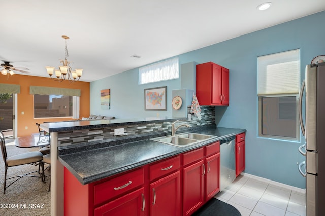 kitchen with dark countertops, appliances with stainless steel finishes, a sink, and plenty of natural light