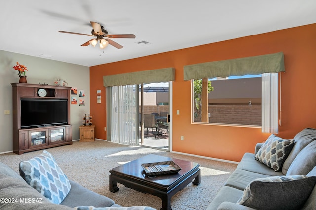 carpeted living area with visible vents, baseboards, and ceiling fan