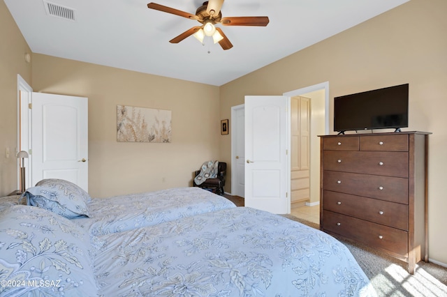 bedroom featuring a ceiling fan, visible vents, and light colored carpet