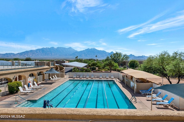 pool with fence, a patio area, and a mountain view