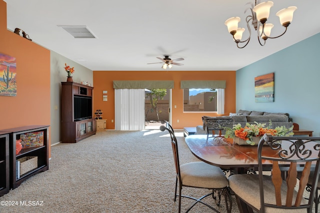 carpeted dining area with visible vents, baseboards, and ceiling fan with notable chandelier