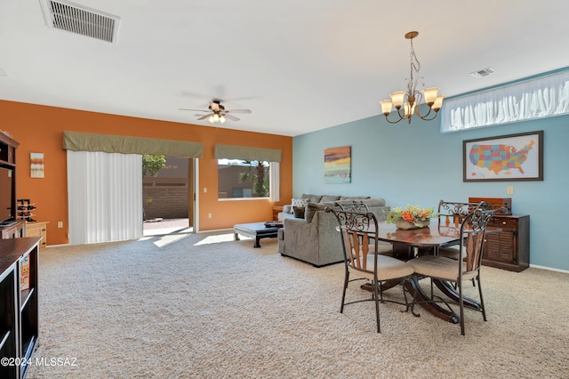 dining area featuring carpet floors, visible vents, and ceiling fan with notable chandelier