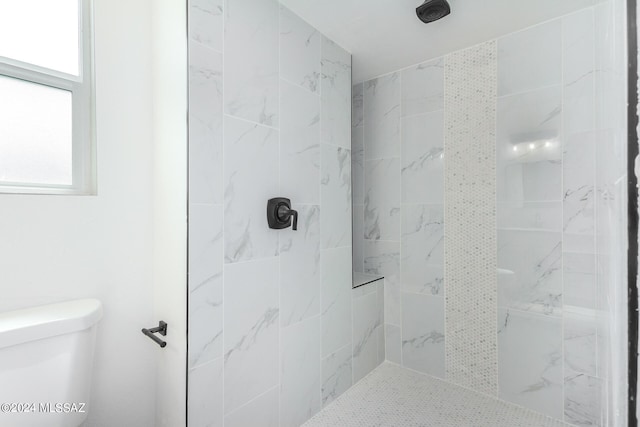 bathroom featuring toilet and tiled shower