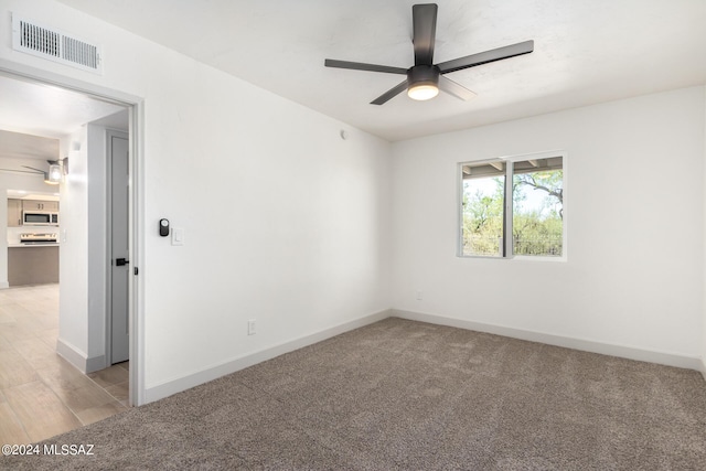 spare room featuring ceiling fan and light hardwood / wood-style flooring