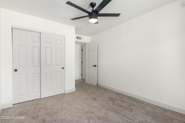 unfurnished bedroom featuring a closet, light colored carpet, and ceiling fan