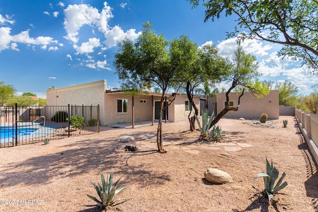 view of front of property featuring a fenced in pool and a patio