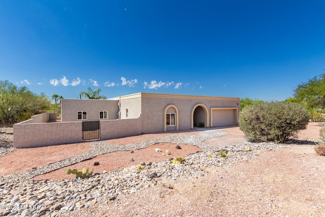 pueblo-style house featuring a garage