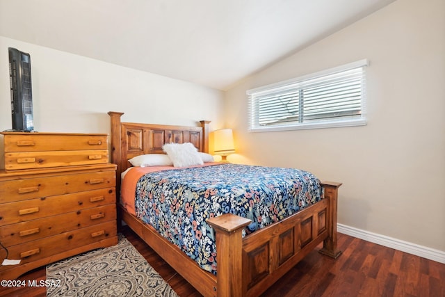 bedroom with vaulted ceiling and dark hardwood / wood-style flooring