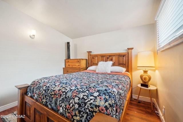 bedroom with dark wood-type flooring and vaulted ceiling