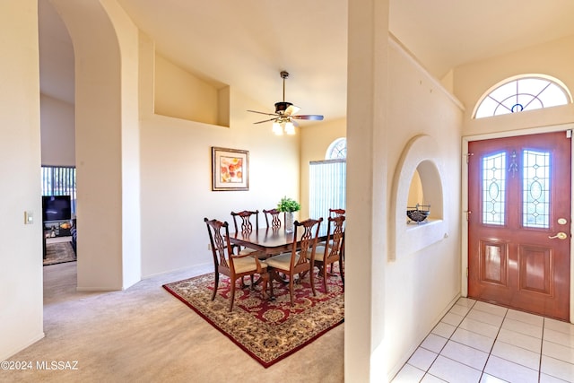 carpeted foyer entrance featuring ceiling fan and high vaulted ceiling