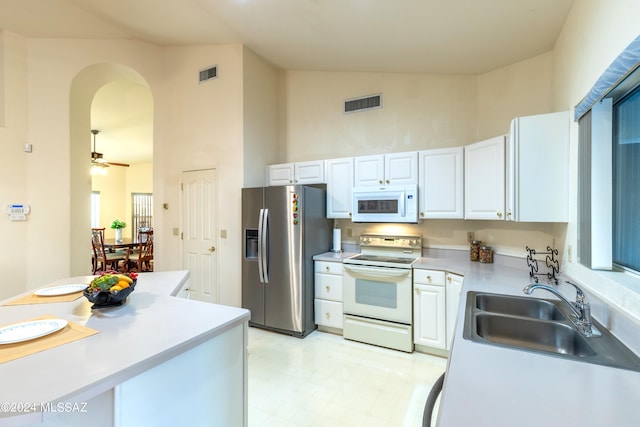 kitchen with white cabinetry, high vaulted ceiling, sink, and white appliances