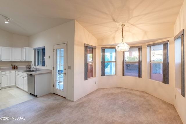 kitchen featuring light carpet, sink, stainless steel dishwasher, white cabinets, and pendant lighting