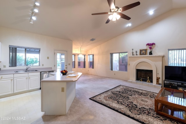 kitchen with white cabinetry, lofted ceiling, sink, and a center island