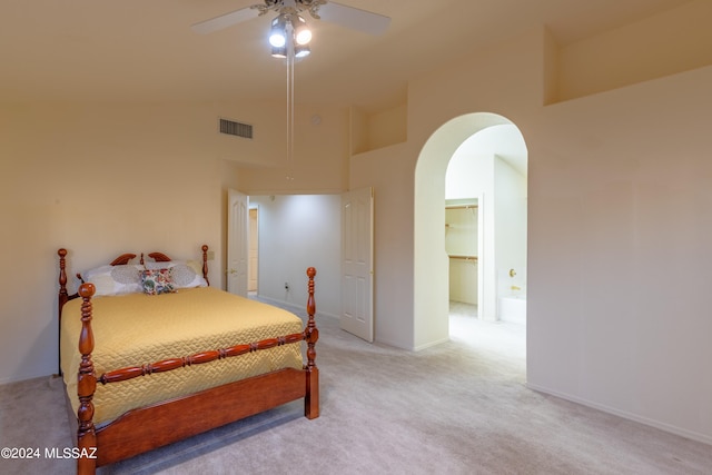 carpeted bedroom featuring a closet, a spacious closet, ceiling fan, and a towering ceiling