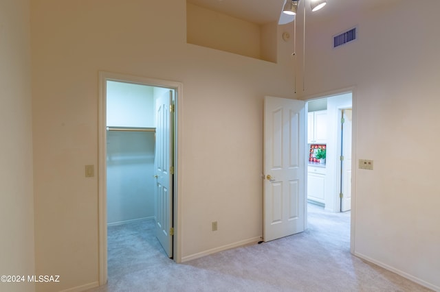 carpeted empty room with a high ceiling