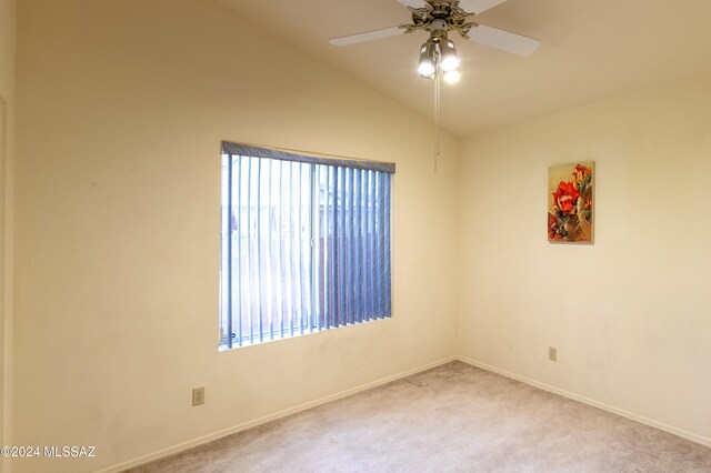 empty room with carpet flooring, ceiling fan, and vaulted ceiling