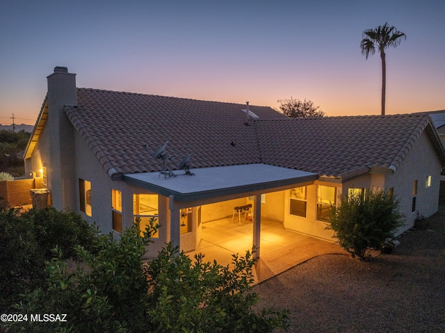 back house at dusk with a patio