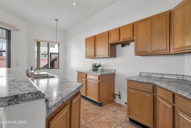 kitchen featuring pendant lighting, light tile patterned floors, and sink