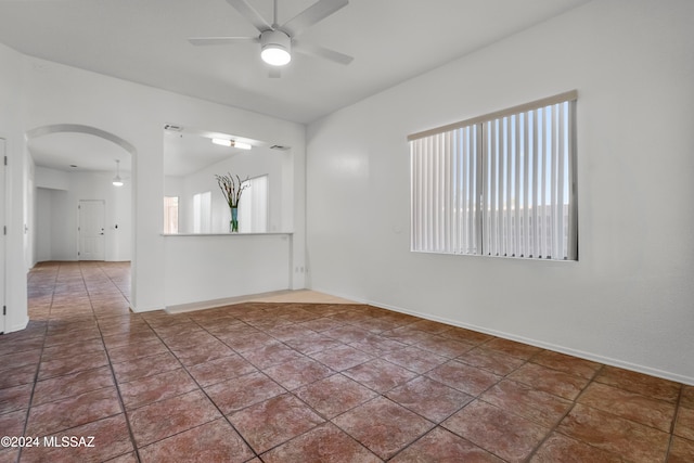 tiled empty room featuring a wealth of natural light and ceiling fan