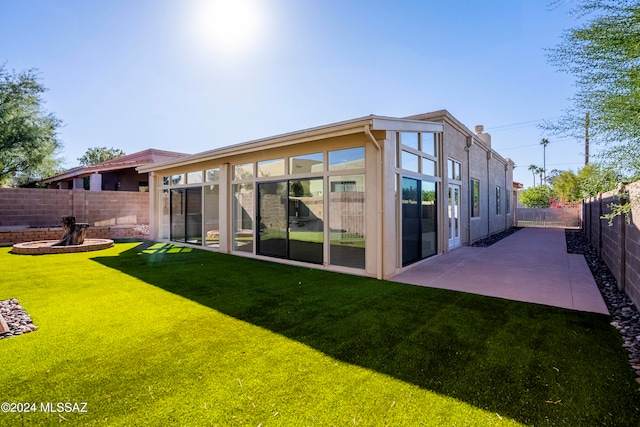 back of property featuring a yard and a patio