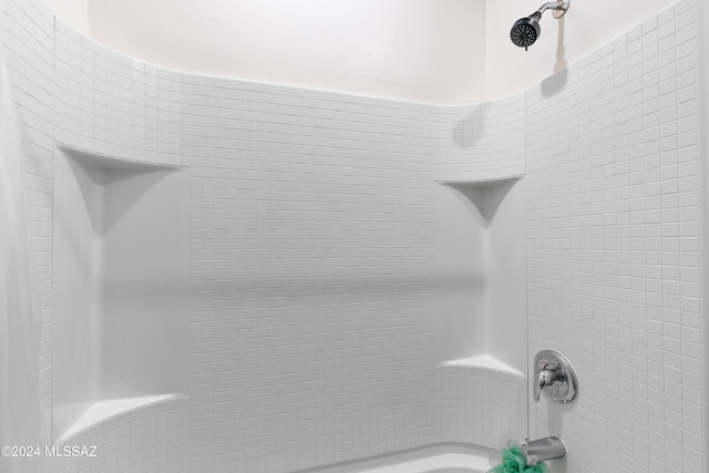 interior details featuring tiled shower / bath combo