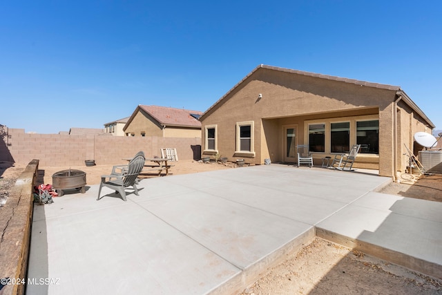 rear view of property featuring an outdoor fire pit, a patio, and central AC unit