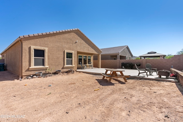 back of property with a gazebo and a patio