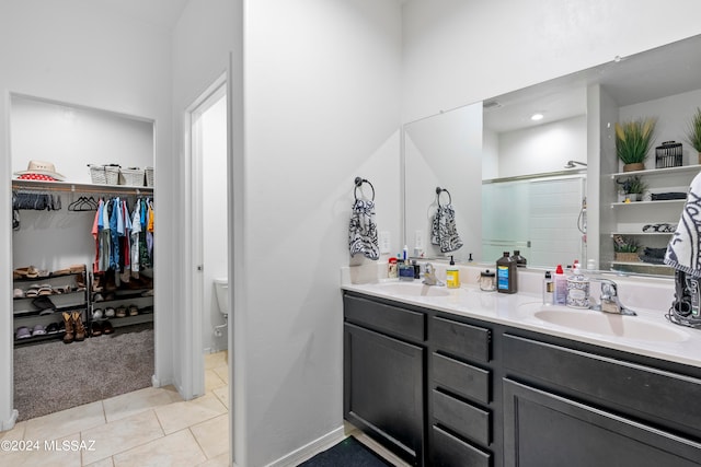 bathroom featuring tile patterned floors, a shower with shower door, vanity, and toilet