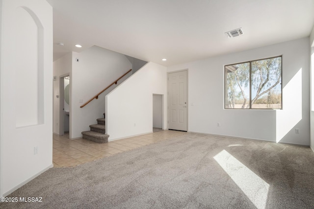 unfurnished living room with light tile patterned floors, recessed lighting, light colored carpet, visible vents, and stairs