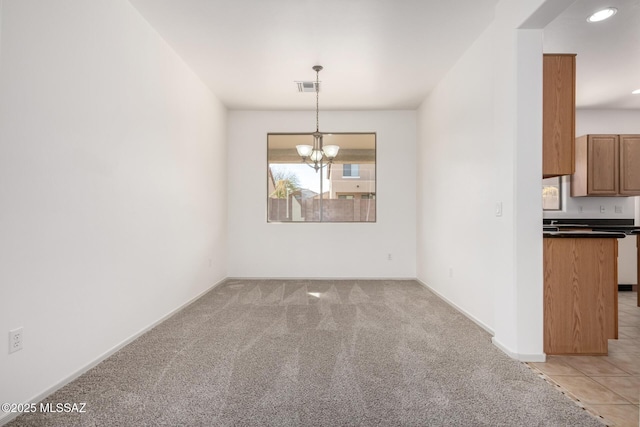 unfurnished dining area with a chandelier, light tile patterned flooring, light carpet, visible vents, and baseboards