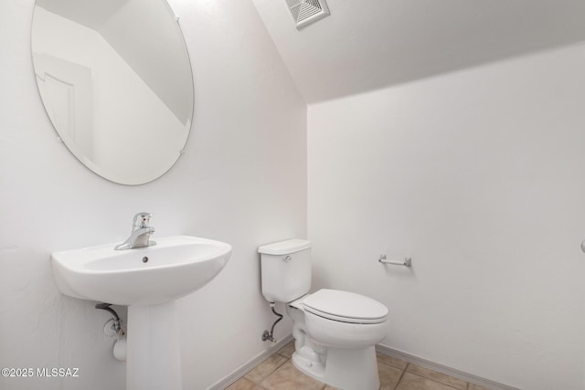 bathroom with tile patterned flooring, baseboards, visible vents, and toilet