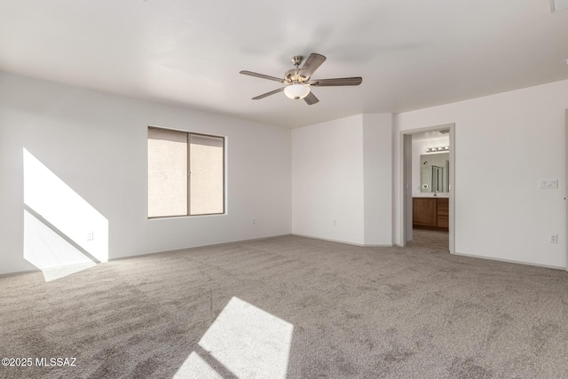 carpeted spare room with a ceiling fan