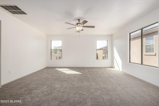 carpeted spare room with ceiling fan and visible vents